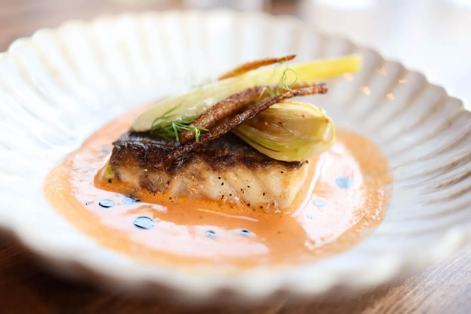 Seasonal fish course on a textured plate